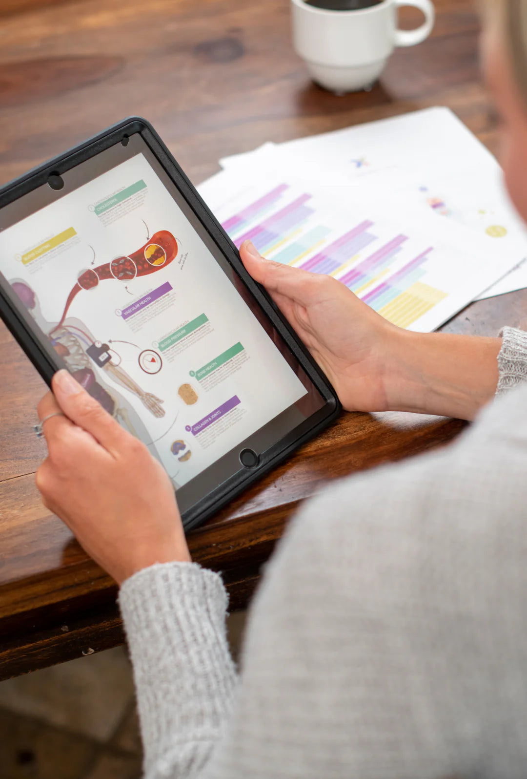Black cylindrical bottle beside tablet showing colorful charts